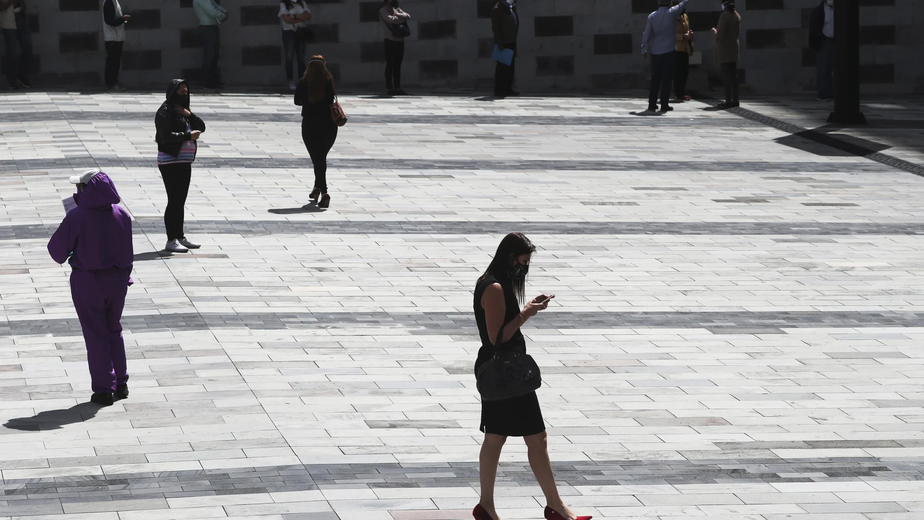 People walk in Quito's financial district in Ecuador, Monday, June 29, 2020. More than 150,000 state workers returned to work today amid fear of increasing COVID-19 infections and the capacity of hospitals to treat them. (AP Photo/Dolores Ochoa)