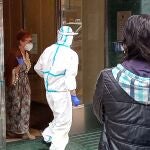 Una de las vecinas del inmueble de Santander en cuarentena que ha dado positivo en la prueba de la covid-19 es trasladada para ser examinada.