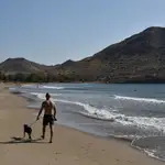 Un hombre pasea a su perro en la playa de los Genoveses en el parque natural Cabo de Gata-Níjar (Almería). EFE / Carlos Barba