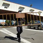 Un Policía Nacional retira la valla de la frontera dejando paso a la entrada de vehículos portugueses en España