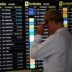 Un pasajero se informa de las llegadas en la terminal 1 del aeropuerto Josep Tarradellas Barcelona El Prat, que está retomando paulatinamente su actividad tras reabrir la UE sus fronteras a 15 países.