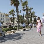 Don Felipe y Doña Letizia saludan a una señora durante su paseo por la Playa de la Malvarrosa