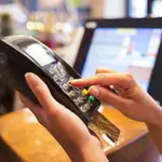 Una persona hace uso de una tarjeta de crédito en un negocio