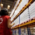 Una trabajadora de Cruz Roja revisa las existencias en el Centro de Almacenamiento y Distribución de Alimentos de Cruz Roja donde han presentado este lunes la primera fase del Programa 2020 de ayuda alimentaria a las personas más desfavorecidas en la Comunitat Valenciana