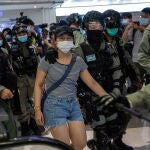 Policías detienen a una mujer en un centro comercial de Hong Kong en medio de las protestas por la ley de seguridad nacional