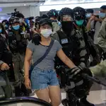 Policías detienen a una mujer en un centro comercial de Hong Kong en medio de las protestas por la ley de seguridad nacional