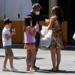 Una familia pasea por una ciudad andaluza equipados con bebidas para mantener una buena hidratación