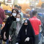 Mujeres iraníes protegidas con mascarillas compran en el gran bazar de Teherán