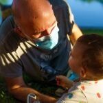 Un padre con mascarilla juega con su hijo