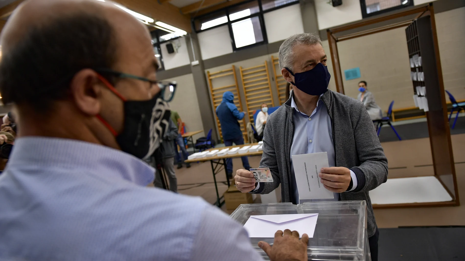 Inigo Urkullo, Basque Lehendakari or Regional President, right, wears a face mask as protection against the coronavirus while voting in a polling station during Basque regional election in the village of Durango, northern Spain, Sunday, July 12, 2020. (AP Photo/Alvaro Barrientos)