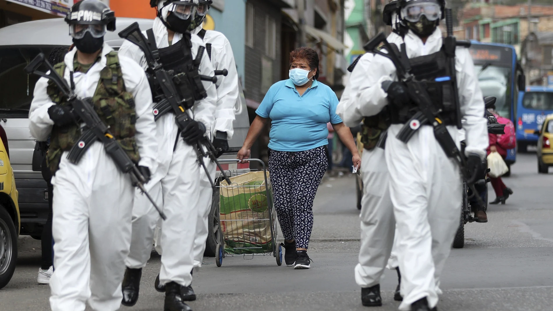 Soldiers in protective gear amid the COVID-19 pandemic patrol in Ciudad Bolivar, an area with high cases of the new coronavirus in Bogota, Colombia, Monday, July 13, 2020. The mayor of Bogota ordered tight restrictions in areas seeing the highest contagion. (AP Photo/Fernando Vergara)