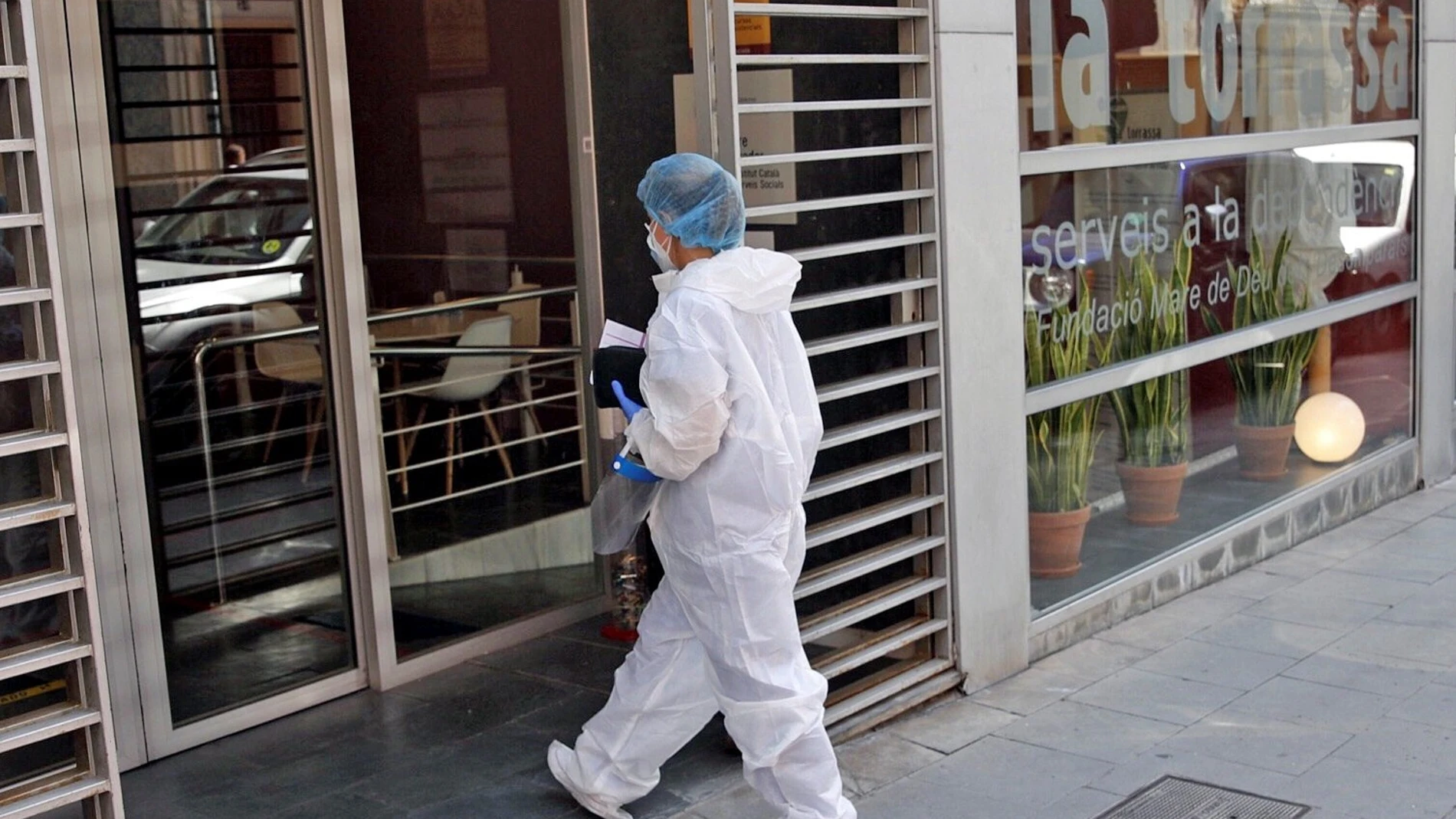 Una sanitaria entra en la residencia geriátrica del barrio de La Torrassa en L'Hospitalet (Barcelona), donde se ha detectado un brote de covid-19 que afecta a mas de 100 personas