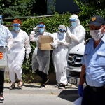 Miembros de la Comisión Electoral Estatal de Macedonia del Norte con ropa protectora recogen los votos de los ciudadanos en cuarentena