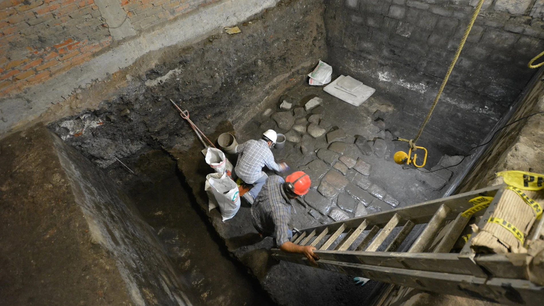 Archaeologists from Mexico's National Institute of Anthropology and History (INAH) work on slabs of basalt, belonging to vestiges of a pre-Hispanic palace and the residence of conqueror Hernan Cortes in Mexico City