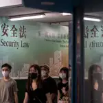 Ciudadanos hongkoneses pasan frente a un póster gigante sobre la nueva ley de seguridad nacional impuesta por China