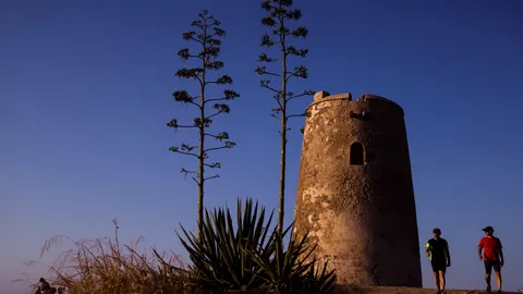 Dos personas pasean por la Senda del Litoral, un recorrido de 113 kilómetros al borde del Mediterráneo que atraviesa 14 municipios, ayer en el barrio de la Araña de Málaga