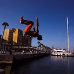 Un joven salta hacia el agua en el Muelle 1 del puerto de Málaga