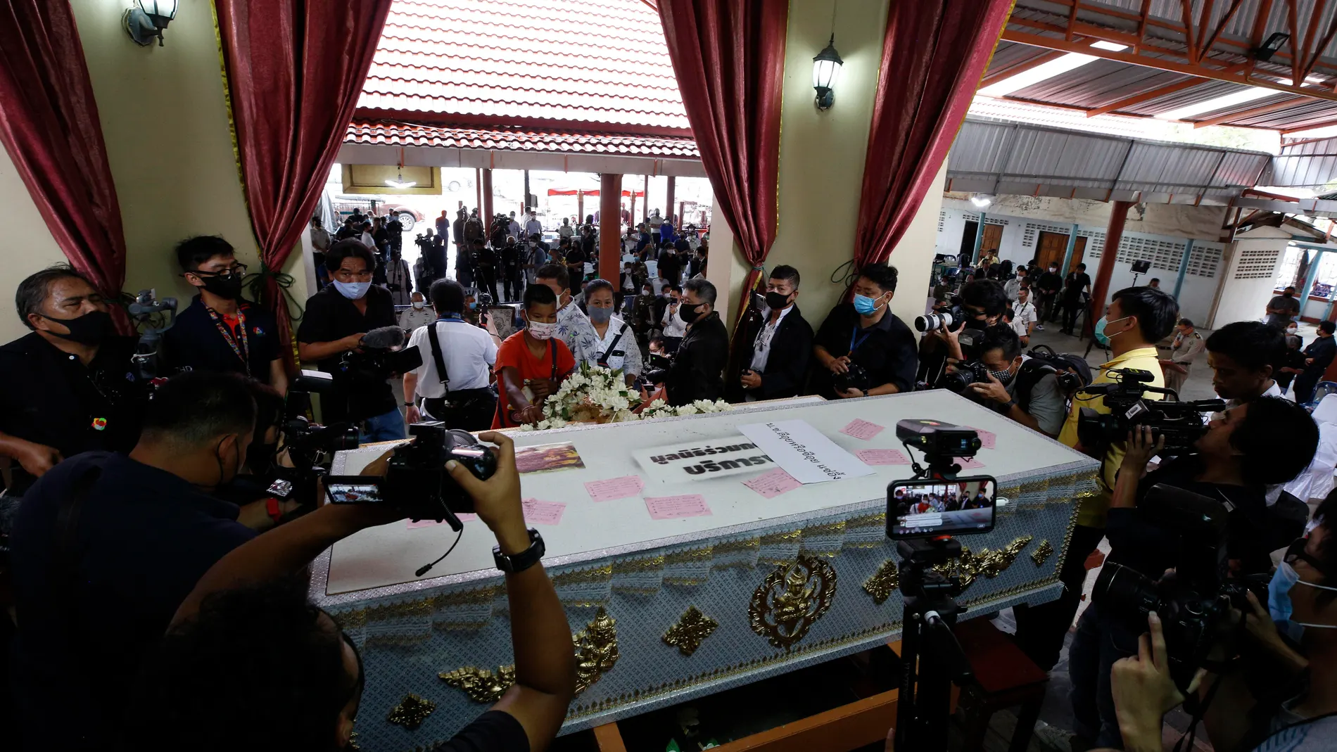 Nonthaburi (Thailand), 23/07/2020.- People gather around a coffin during the ceremony for the cremation of late Thai serial killer Si Quey, at Wat Bang Phraek Tai temple in Nonthaburi province, Thailand, 23 July 2020. The cremation was held after 60 years from his execution. The body had been taken for medical studies and preserved in a glass case at the Medical Museum of Siriraj Hospital. Si Quey was arrested in 1958 and convicted for murdering and eating seven children. He was executed in 1959 at Bang Kwang prison. (Tailandia) EFE/EPA/NARONG SANGNAK