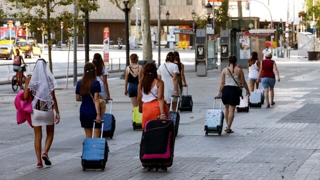 Varias turistas caminan por la Plaza Cataluña de Barcelona, hoy domingo, después de quel os rebrotes de coronavirus que han aparecido en las últimas semanas en Cataluña hayan provocado una oleada de cancelaciones en Barcelona y que algunos hoteles que habían reabierto tras la apertura de las fronteras vuelvan a cerrar. EFE/Quique García