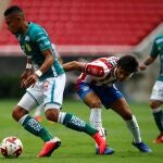 José Juan Macías, de Chivas disputa el balón con William Tesillo.