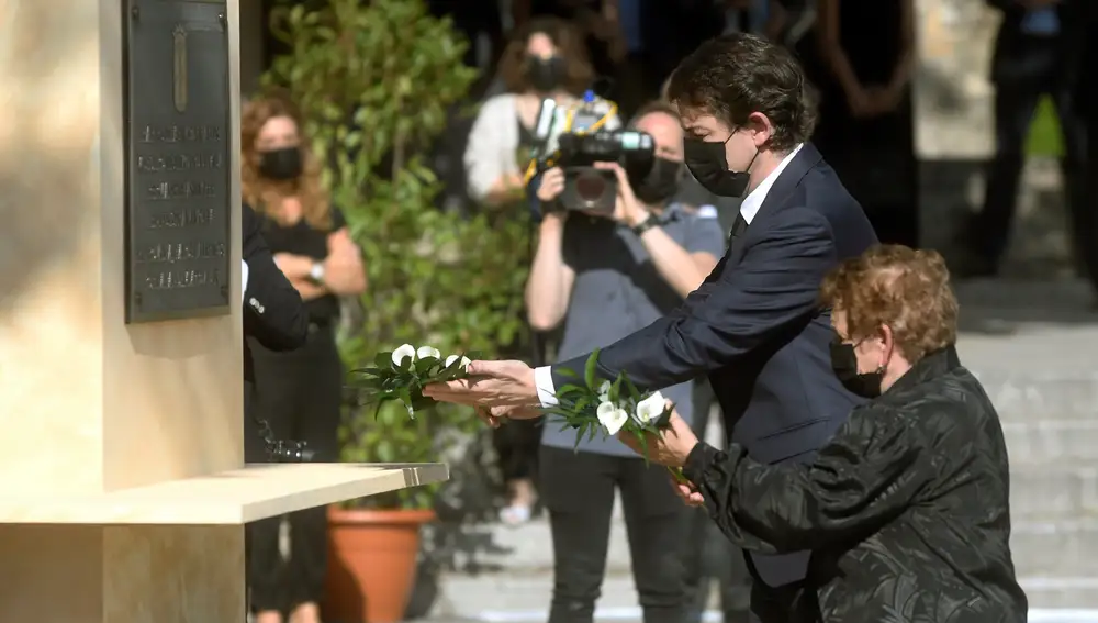 SEGOVIA 27/07/2020.- El presidente de la Junta de Castilla y León, Alfonso Fernández Mañueco, y Sara Doce, familiar de una de las víctimas, depositan flores ante un monumento mientras participan en el acto de homenaje de la Comunidad a las víctimas de la COVID-19 y a todas las personas que luchan contra la pandemia, este lunes en Segovia. EFE/Pablo Martín