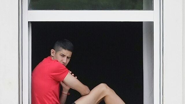 Un jugador del Fuenlabrada, en la ventana del hotel donde está confinado el equipo en La Coruña