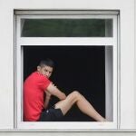 Un jugador del Fuenlabrada, en la ventana del hotel donde está confinado el equipo en La Coruña