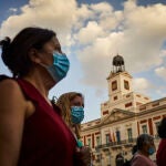 Varios ciudadanos pasean con mascarilla por la Puerta del Sol, frente a la sede del Gobierno de la Comunidad de Madrid