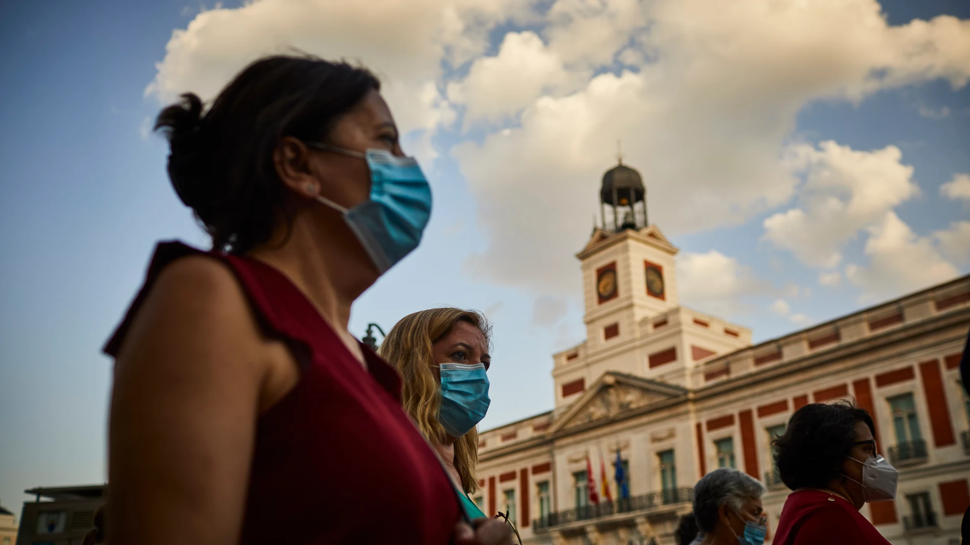 Varios ciudadanos pasean con mascarilla por la Puerta del Sol, frente a la sede del Gobierno de la Comunidad de Madrid