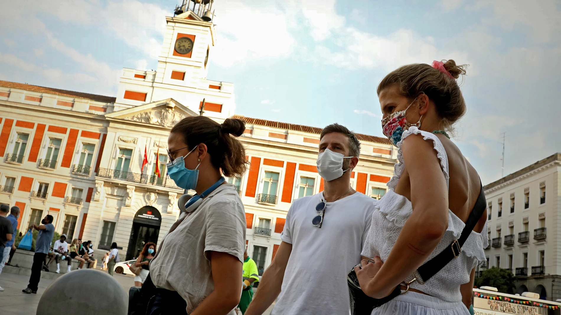 Madrileños con mascarilla pasean por los alrededores de la Puerta del Sol