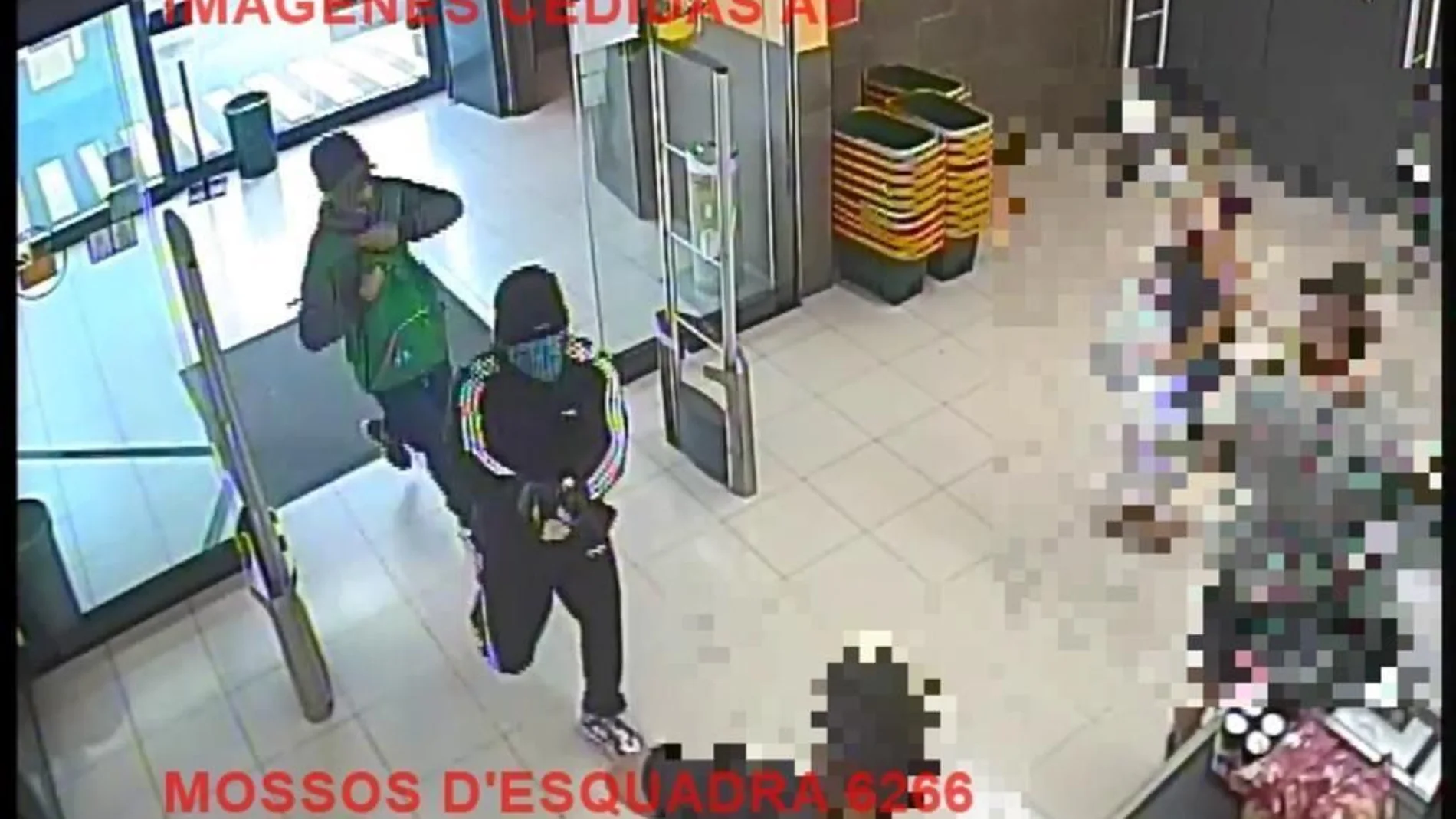 Imagen de los dos hombres entrando al supermercado armados