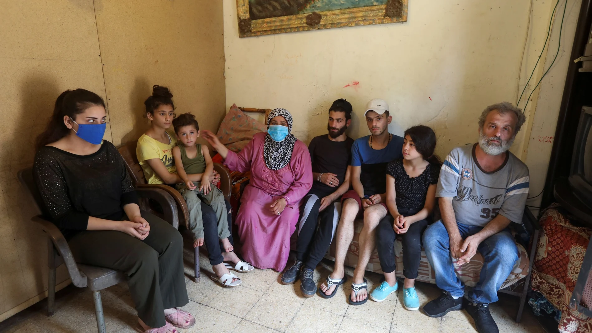 Iman al-Ali sits with her family in a room in Tripoli