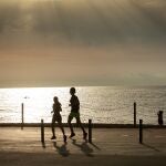 Dos ciudadanos practican deporte frente a la playa de la Barceloneta en Barcelona.