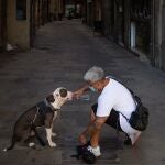 Un hombre da de beber a su perro en el centro de Barcelona el pasado martes