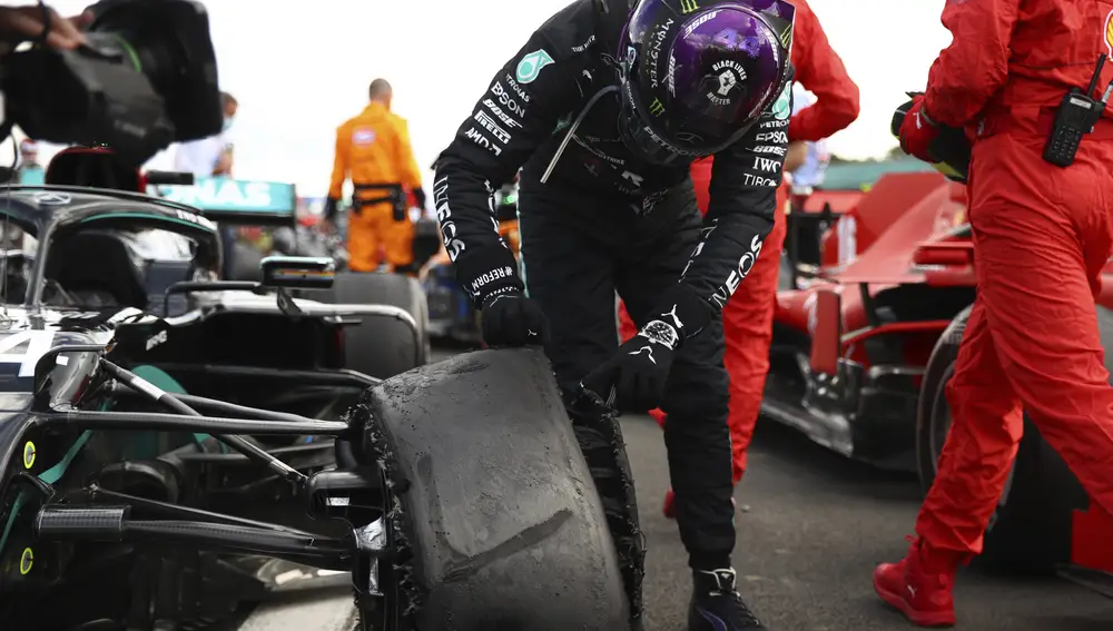 Mercedes driver Lewis Hamilton of Britain inspects puncture on his car after winning the British Formula One Grand Prix at the Silverstone racetrack, Silverstone, England, Sunday, Aug. 2, 2020. (Bryn Lennon/Pool via AP)