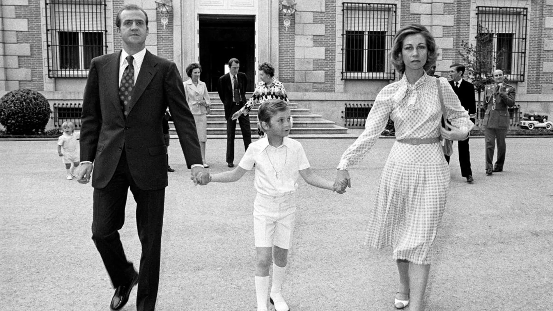 Don Juan Carlos y Doña Sofía de la mano del entonces Príncipe Felipe, durante el día de su primera comunión en Zarzuela.