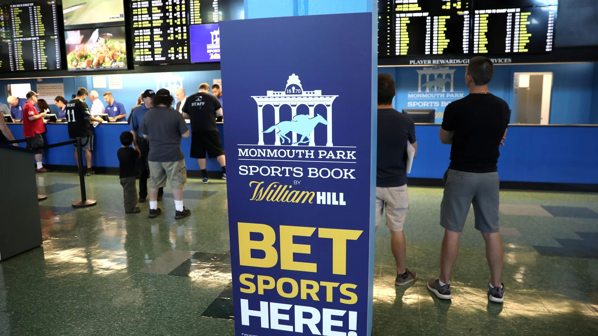 FILE PHOTO: Gamblers place bets on sports at Monmouth Park Sports Book by William Hill, shortly after the opening of the first day of legal betting on sports in Oceanport