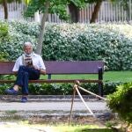 Imagen de un jubilado leyendo un libro en un parque