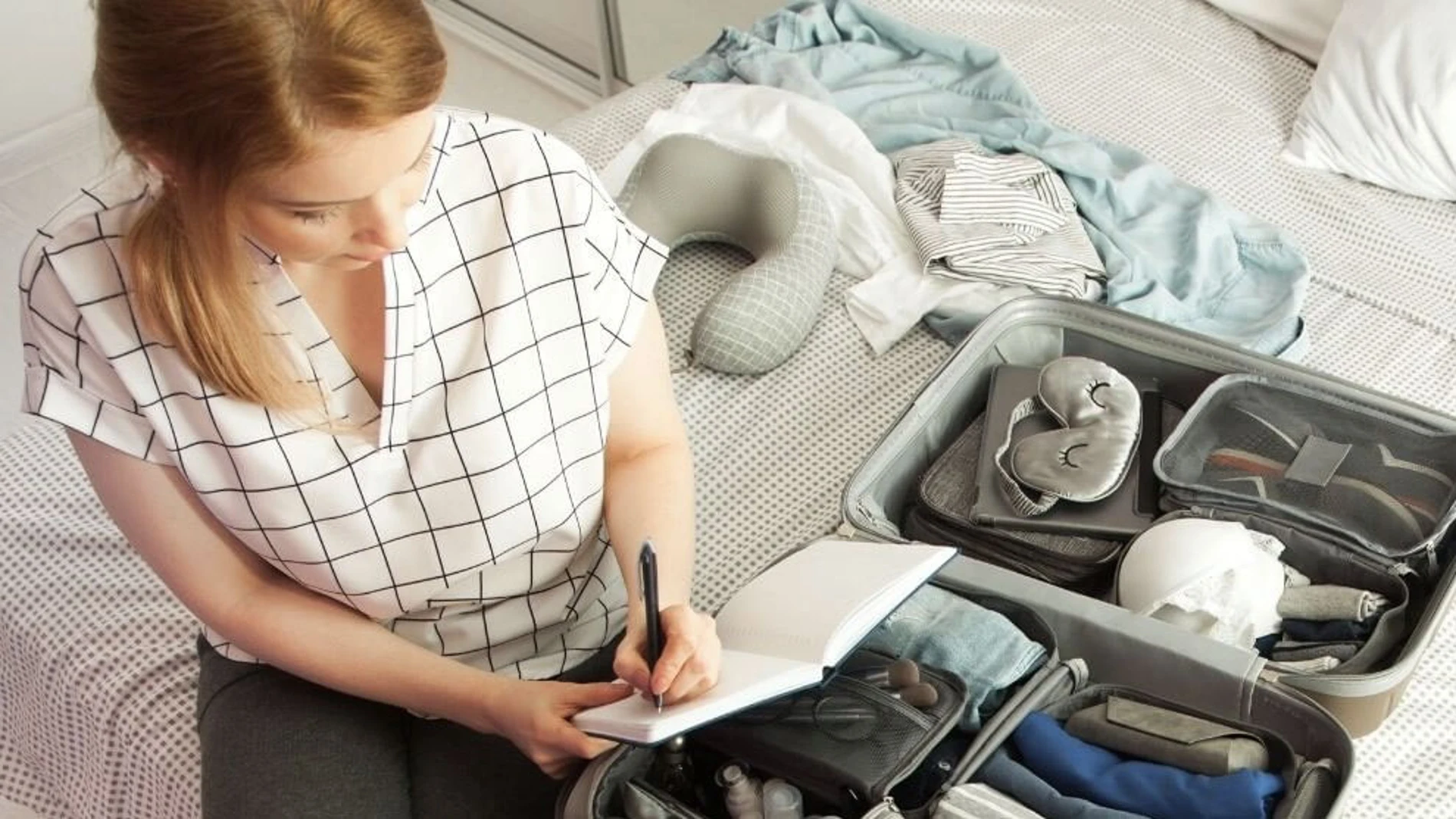 Una mujer prepara su maleta de viaje