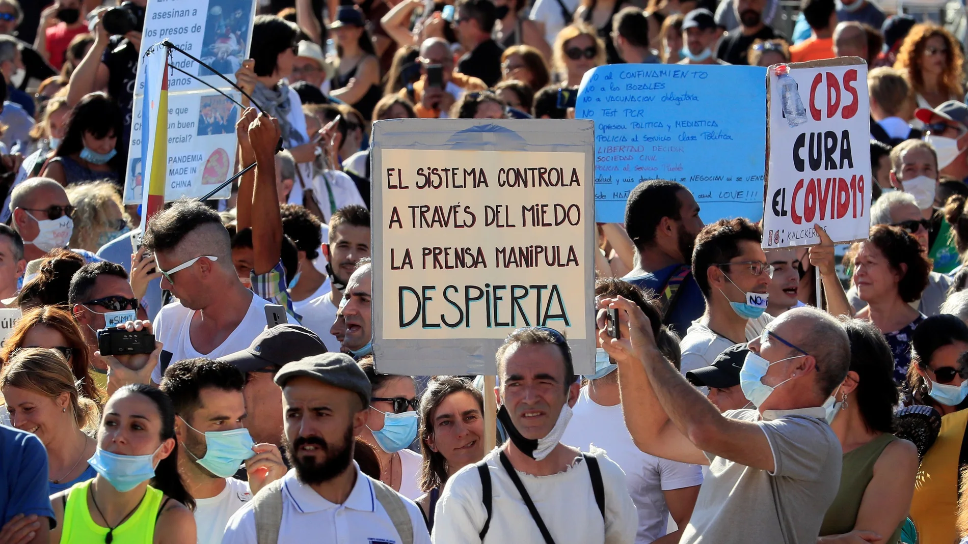 Asistentes a la manifestación que se ha celebrado esta tarde en la Plaza de Colón de Madrid convocada en redes sociales en contra del uso de las mascarillas