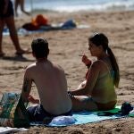 Una joven fumaen la playa de La Patacona de Alboraia (Valencia)