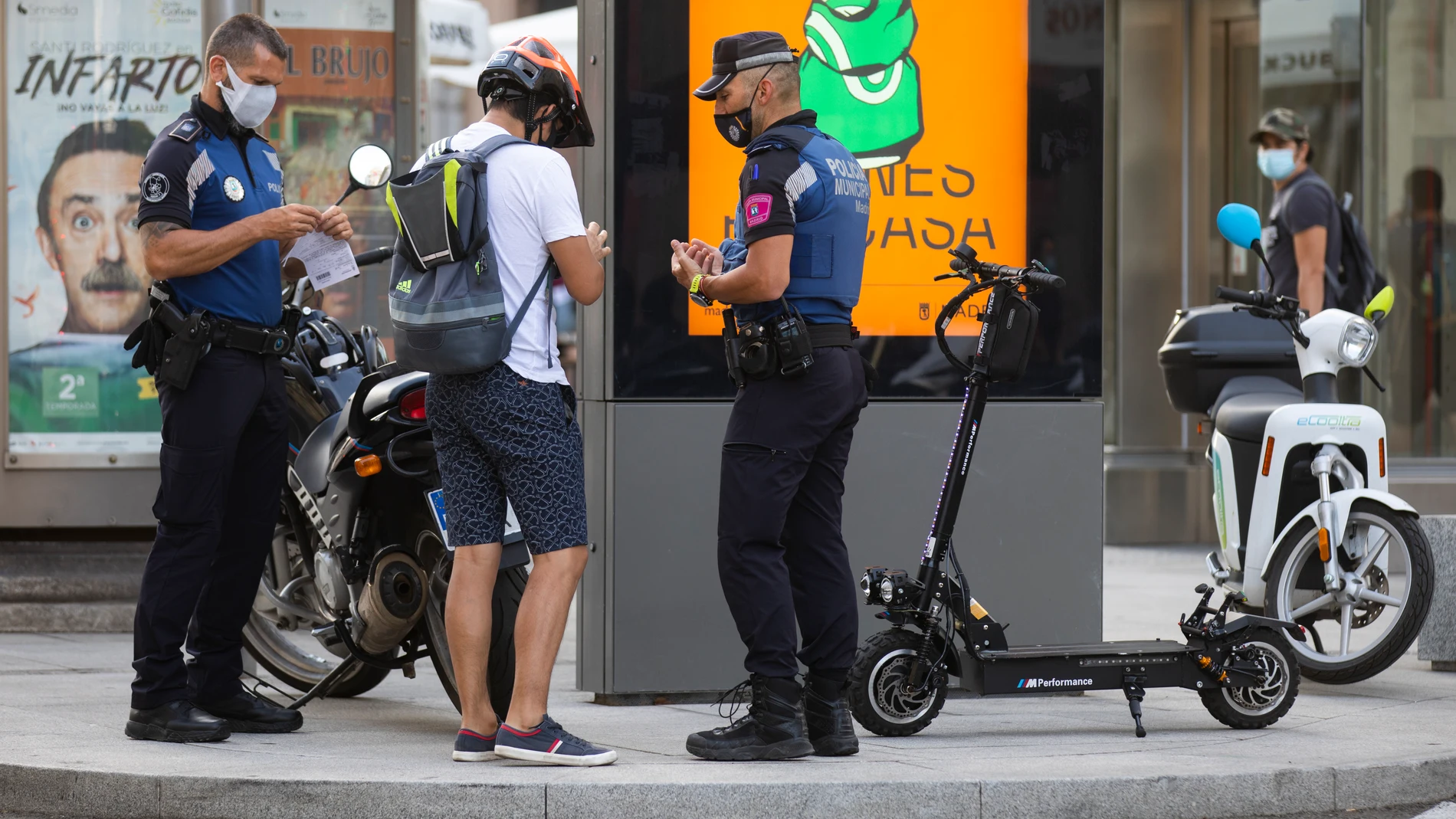 Imagen de un joven que es requerido por la policia municipal para que les muestre la documentación de su patinete eléctrico