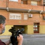 Un cámara graba el portal del edificio de la localidad de l'Alcudia de Crespins (Valencia), donde la Guardia Civil halló, ayer jueves, el cadáver de una mujer de unos 45 años que llevaba varios meses muerta, y ha detenido a su hija y al novio de ésta