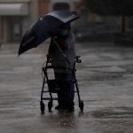 AME9911. GUAYAMA (PUERTO RICO), 22/08/2020.- Un hombre que se apoya en un caminador lidia con su sombrilla durante la lluvia debido al paso de la tormenta Laura hoy, en Guayama, sur de Puerto Rico. La tormenta tropical Laura está descargando fuertes lluvias sobre "porciones" de Puerto Rico y más tarde pasará cerca o sobre la Española (República Dominicana y Haití), mientras al otro lado del Caribe la tormenta Marco se ha fortalecido entre Cuba y México cerca del canal de Yucatán y podría convertirse hoy en huracán. Las dos tormentas tienen a una gran parte del Caribe en alerta y también a estados de EE.UU. como Luisiana, Misisipi, Alabama y Texas, donde, según los patrones de trayectoria del Centro Nacional de Huracanes, pueden impactar a principios de la semana entrante. EFE/ Thais Llorca