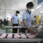 Operarios fabrican mascarillas contra el coronavirus en una fábrica de Taipéi (Taiwán)