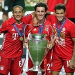 Odriozola, con la Champions en el césped de Da Luz con Thiago (izquierda) y Coutinho al lado