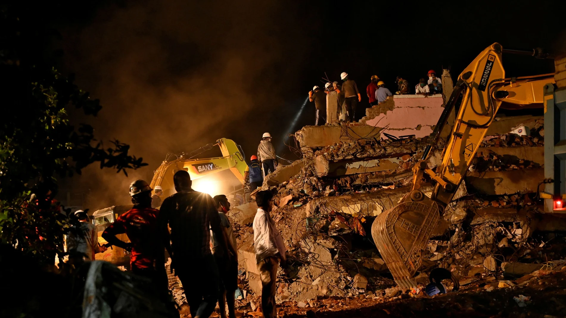 Rescue workers remove the debris as they search for survivors after a five-storey building collapsed in Mahad