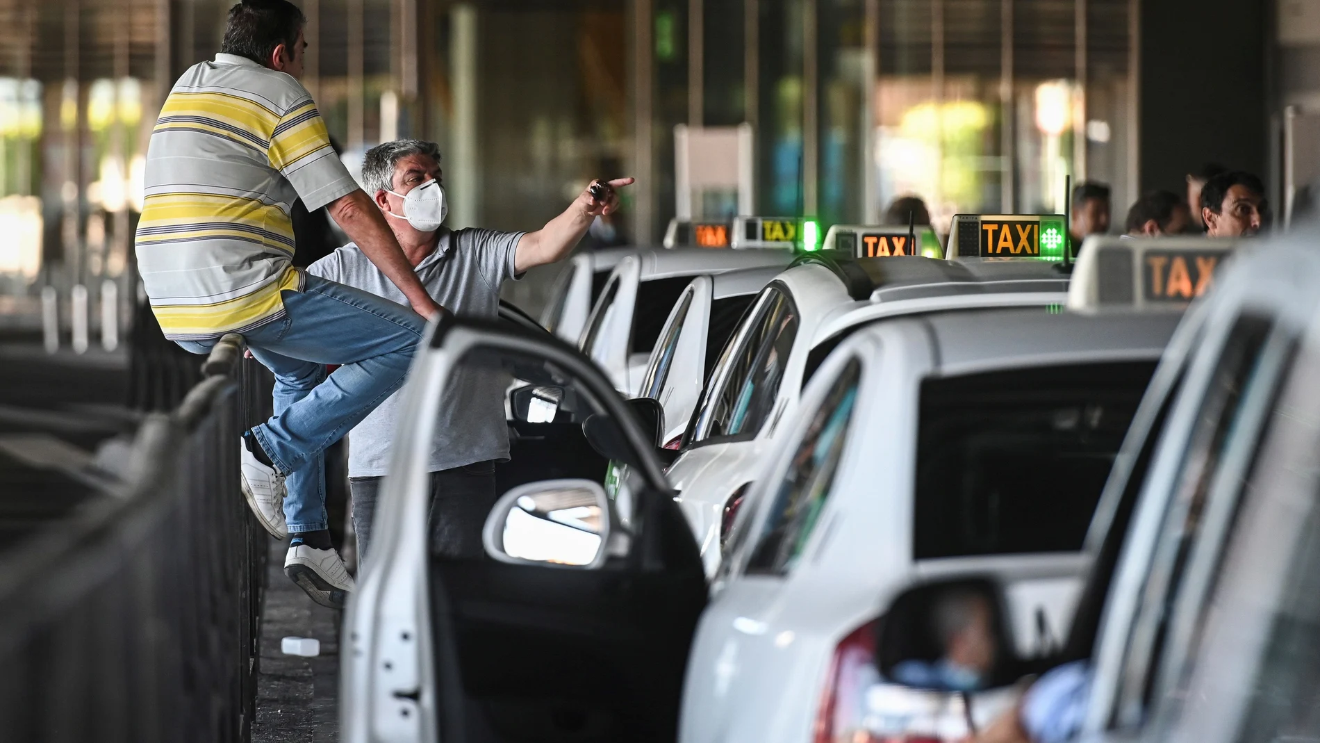 Taxistas esperan la llegada de viajeros en la parada de taxis de la Terminal 1 del Aeropuerto Adolfo Suarez