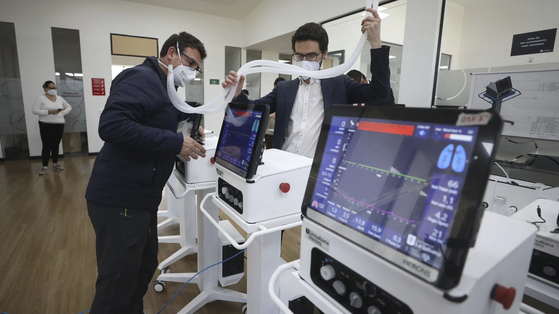 Engineers from La Sabana University demonstrate low-cost ventilators for patients with COVID-19 in Bogota, Colombia, Monday, July 6, 2020. The machine called the Heron looks like many other ventilators used to treat COVID-19 patients, but this device costs about $4,000, a fifth of the price of ventilators imported from China, and it's made in Colombia, where some hospitals have been overwhelmed by coronavirus patients. (AP Photo/Fernando Vergara)