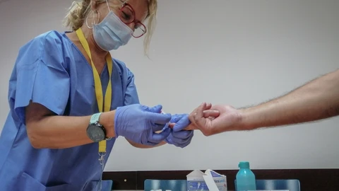 Una sanitaria toma una muestra de sangre de los test rápidos de Covid-19